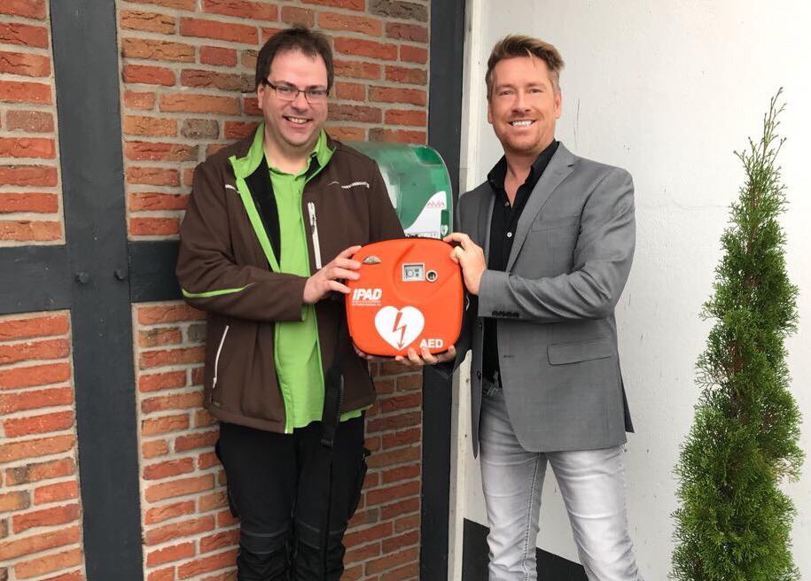 Ingo Fischer vom DRK Ortsverein Dörverden und Kay Zimmer, Geschäftsführer von schuhplus - Schuhe in Übergrößen, nehmen den neuen AED-Standort in Betrieb.