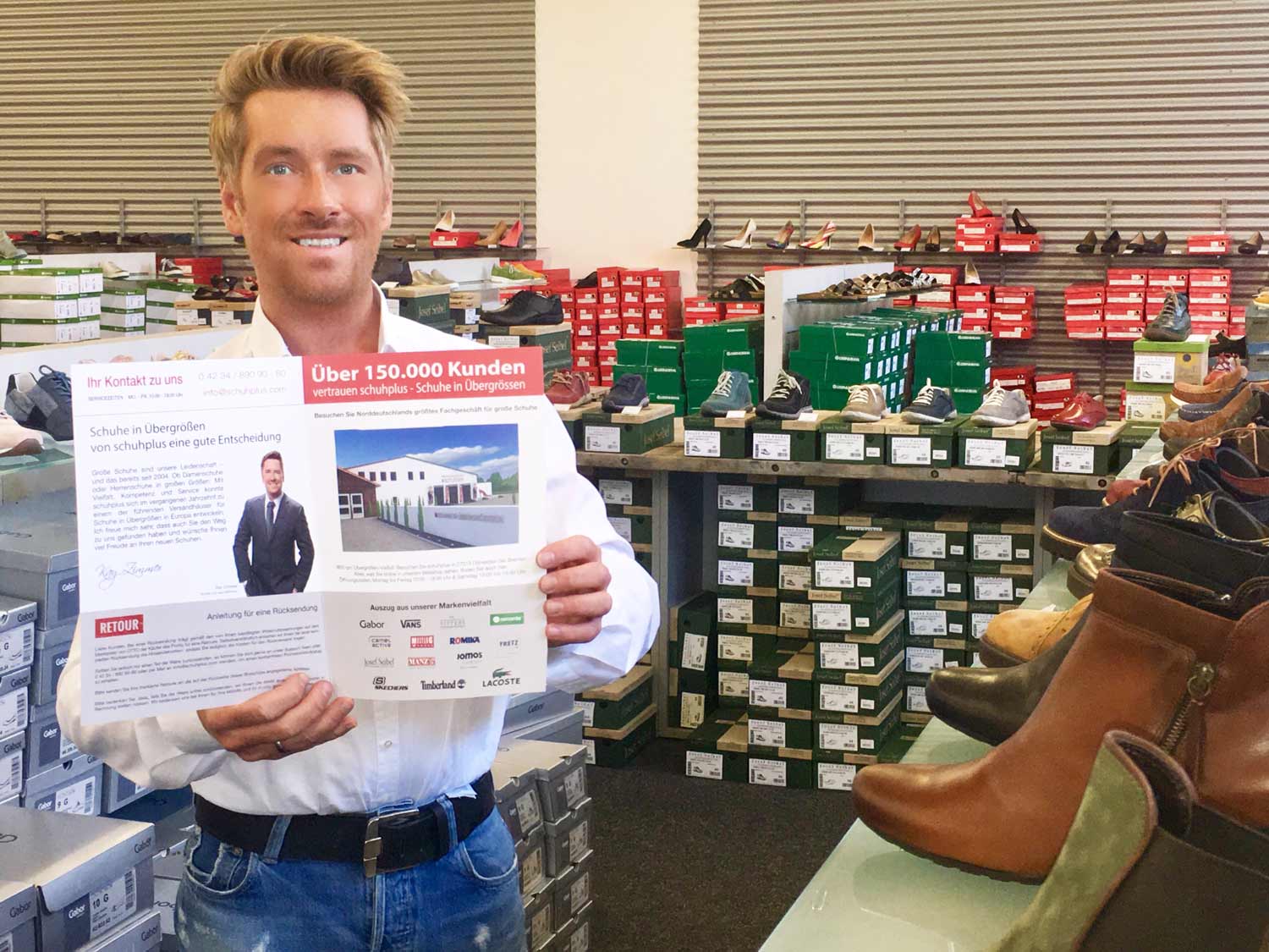 Kay Zimmer, Chef von schuhplus - Schuhe in Übergrößen, in seinem stationären Fachgeschäft für große Schuhe mit den neuen Versandmappen